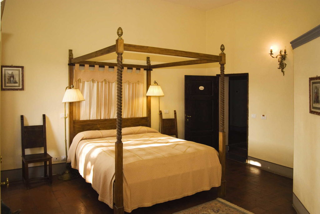 double bed with canopy and chairs on both sides in our Bed And Breakfast in Greve In Chianti, Corte Di Valle.