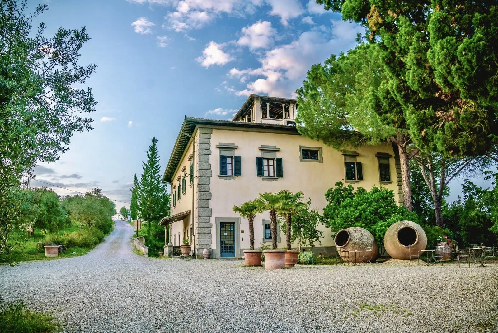 Villa colonica con giardino e vasi grandi.