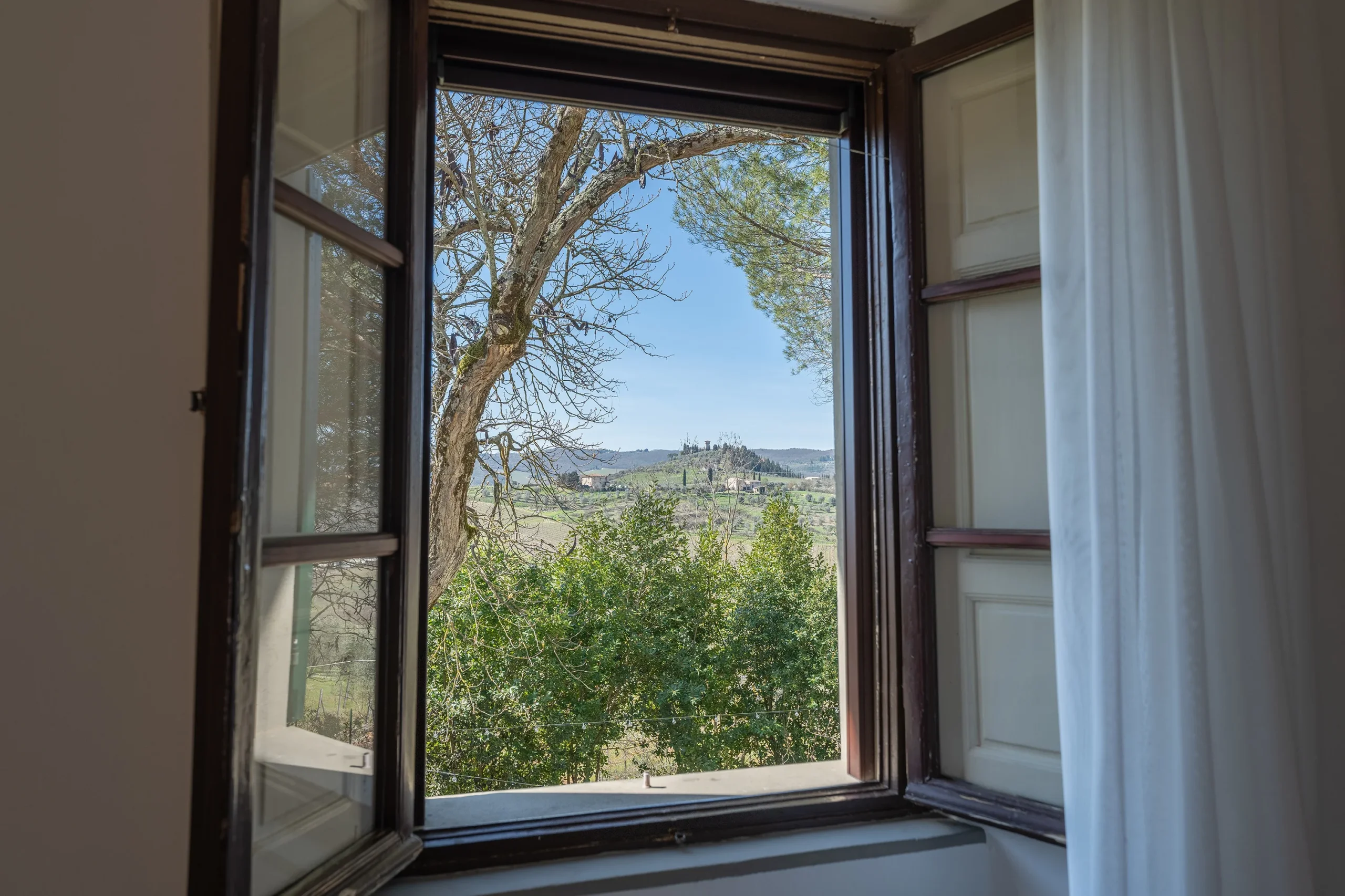 Vista colline toscane da finestra aperta