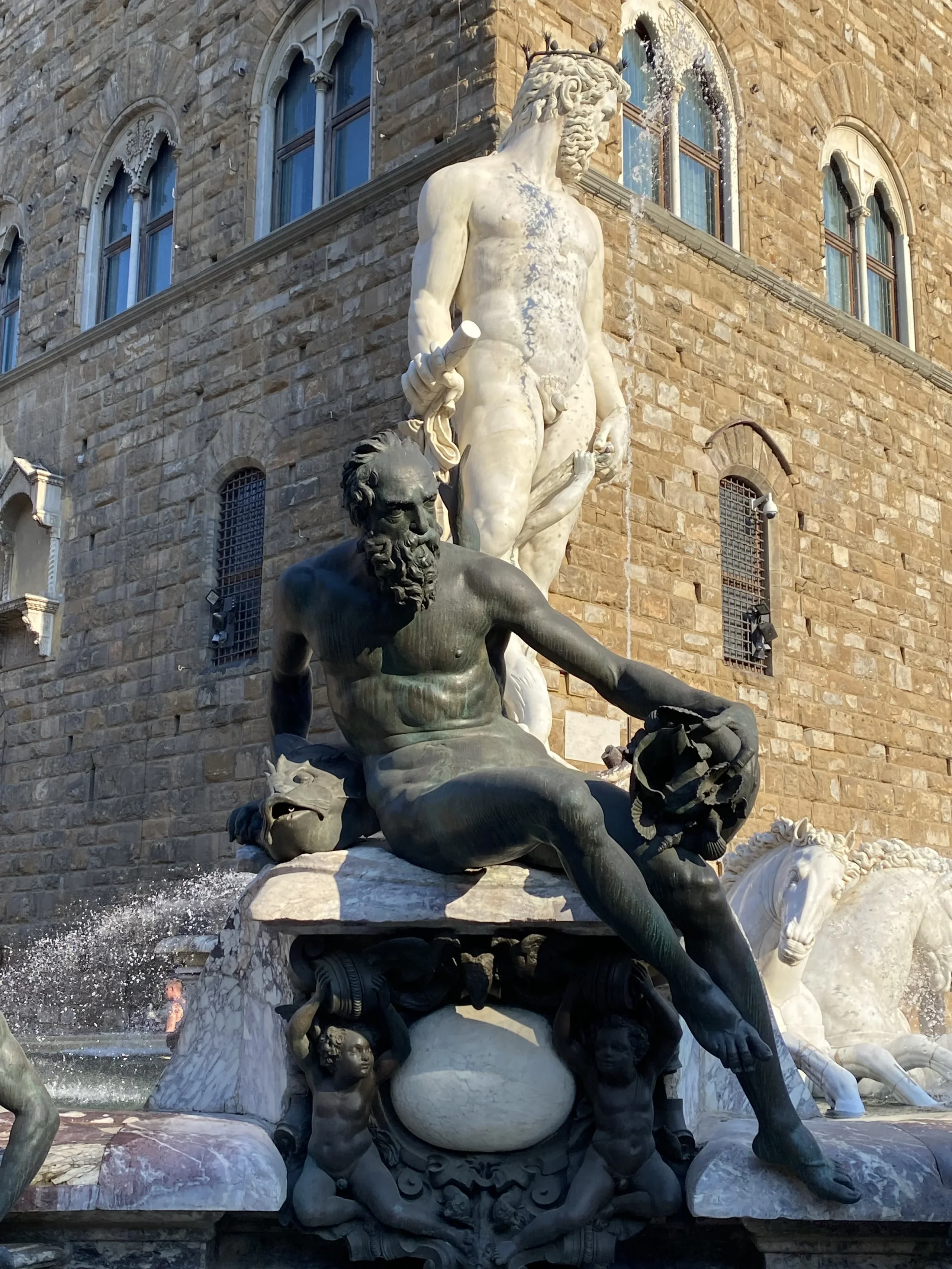 Statue di Nettuno a Firenze davanti a palazzo storico.