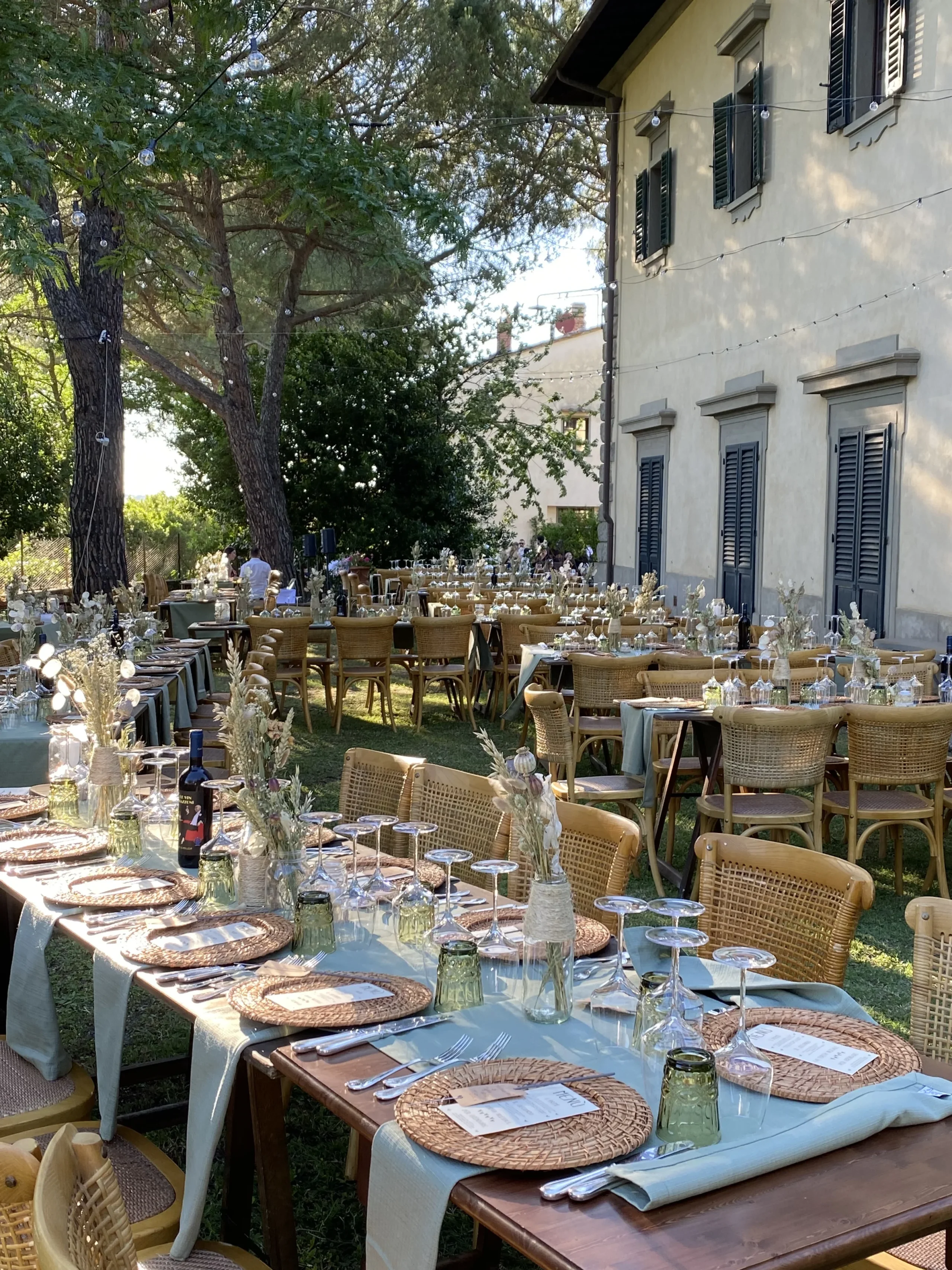 Tavolo all'aperto con decorazioni eleganti e sedie.