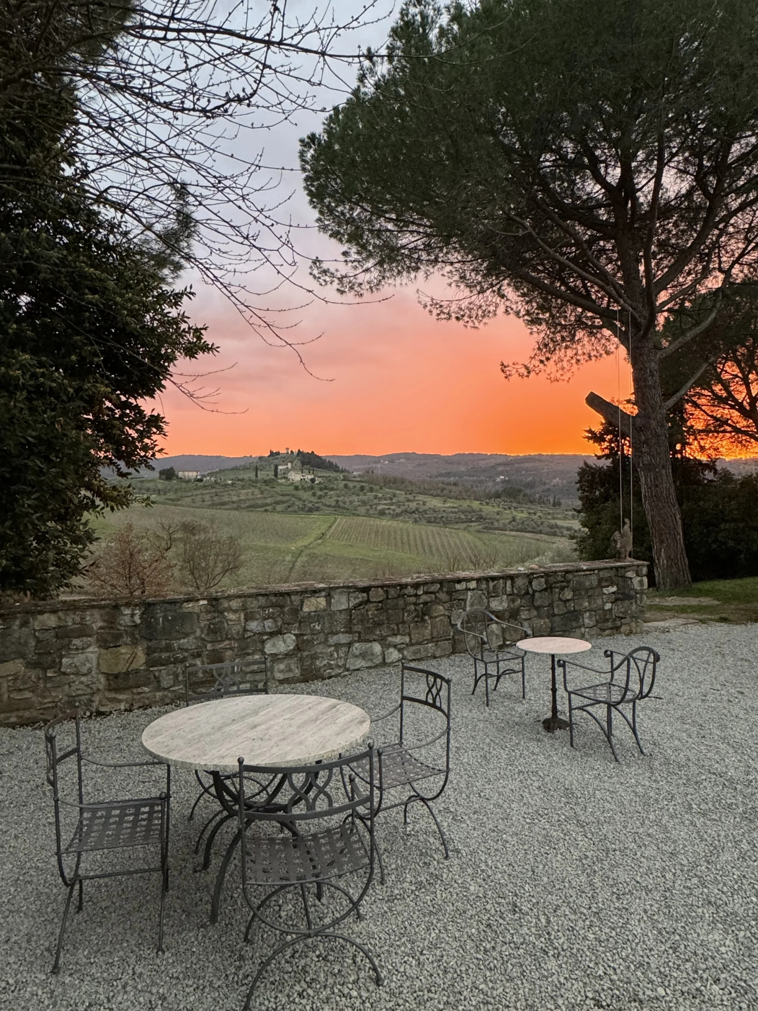 Tramonto su giardino con tavoli e sedie.