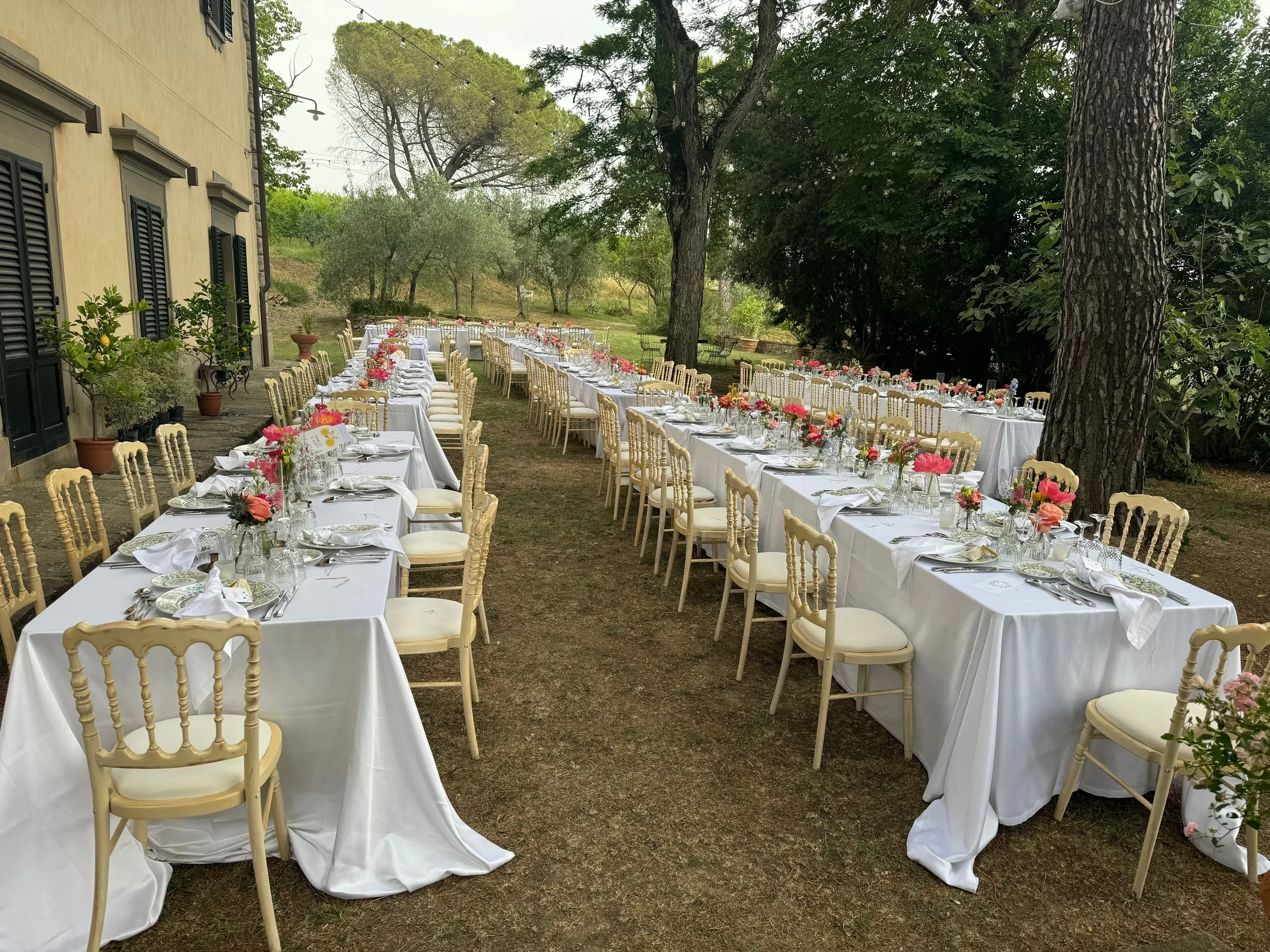 Tavoli da pranzo all'aperto con tovaglie bianche.